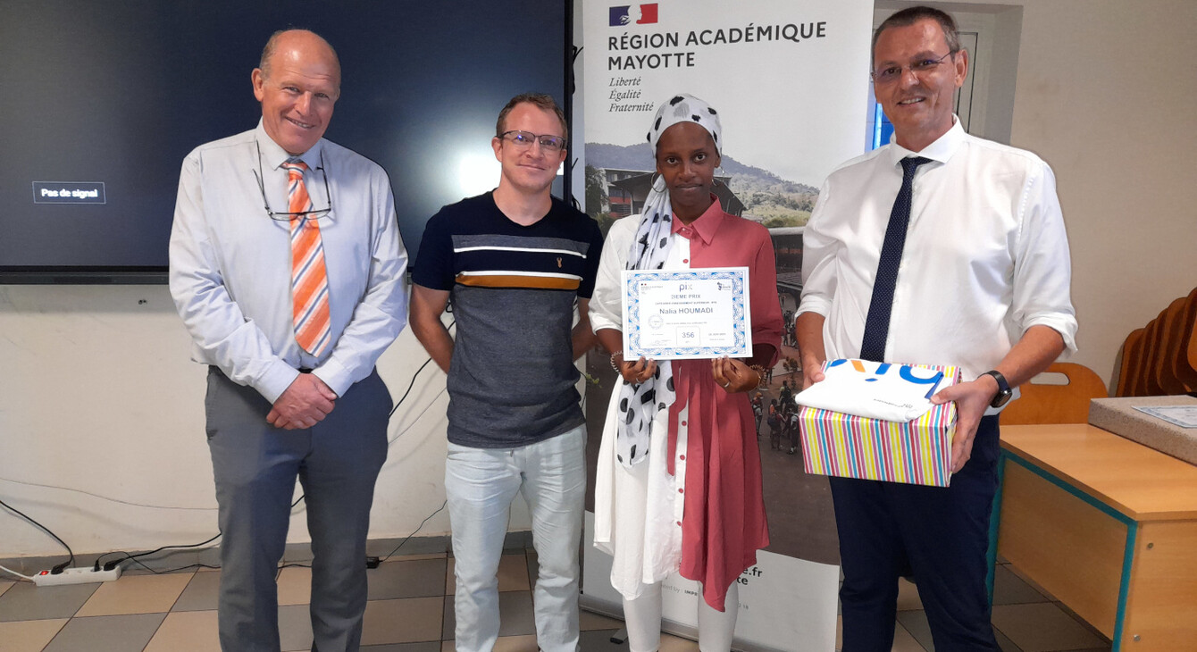 Le recteur et l'ambassadeur PIX remettant un prix a un élève devant son professeur