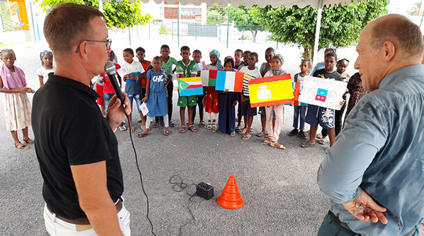 recteur et directeur devant élèves avec des drapeaux